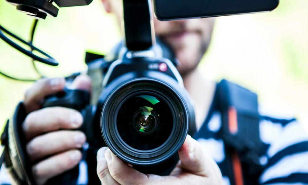 Spain to Tighten Oversight of Far‑Right Movements Following Torre‑Pacheco Violence person holding canon dslr camera close up photo