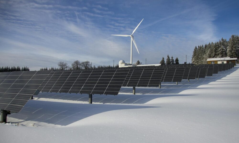 Spain to Host Europe’s First Net‑Positive Energy Building in Climate Innovation Push solar panels on snow with windmill under clear day sky