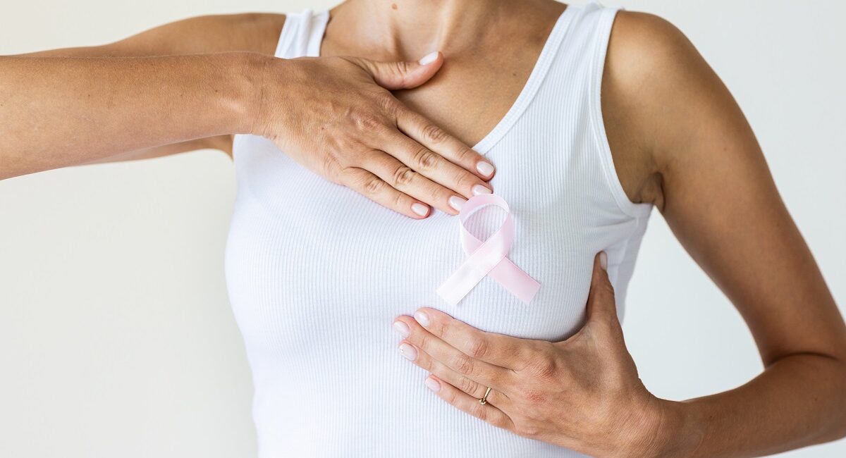 Woman with pink ribbon symbol of breast cancer awareness month.