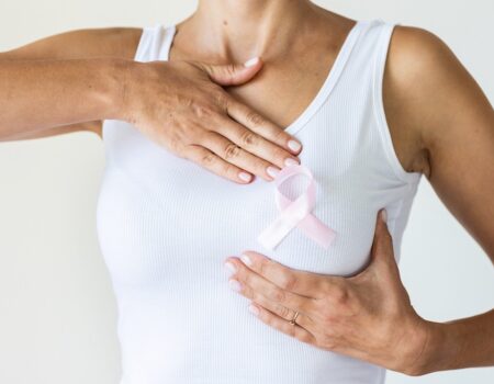 Woman with pink ribbon symbol of breast cancer awareness month.