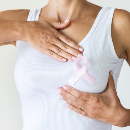 Woman with pink ribbon symbol of breast cancer awareness month.